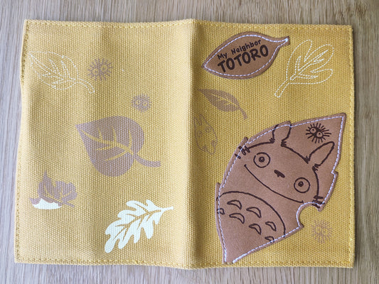 Yellow fabric book cover with Totoro design and 'My Neighbor Totoro' label
